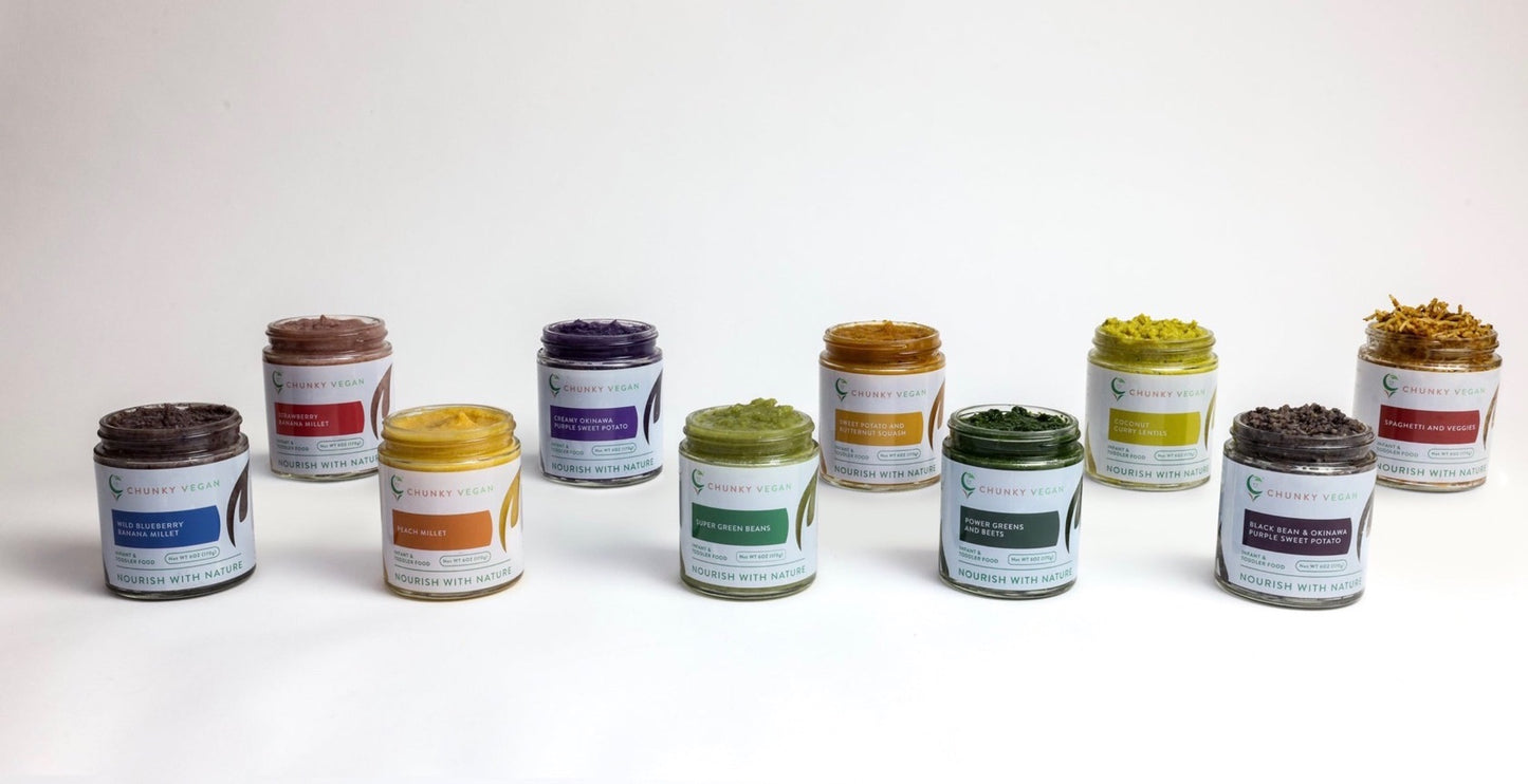 Row of small jars with colorful lids on a white background
