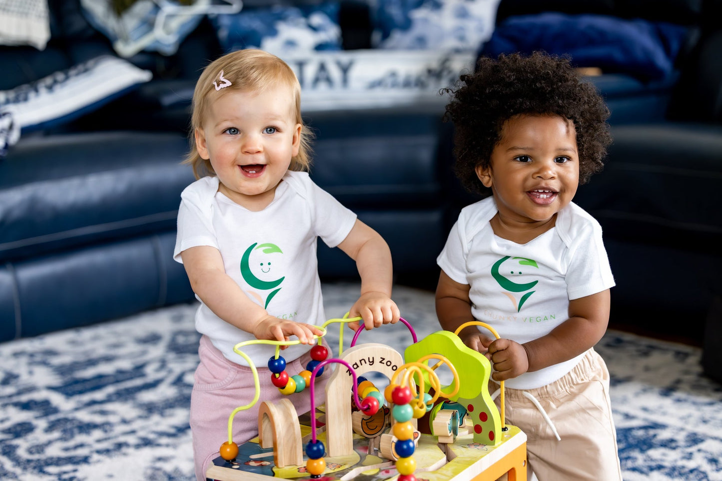 Two children playing with a colorful toy set in a living room.